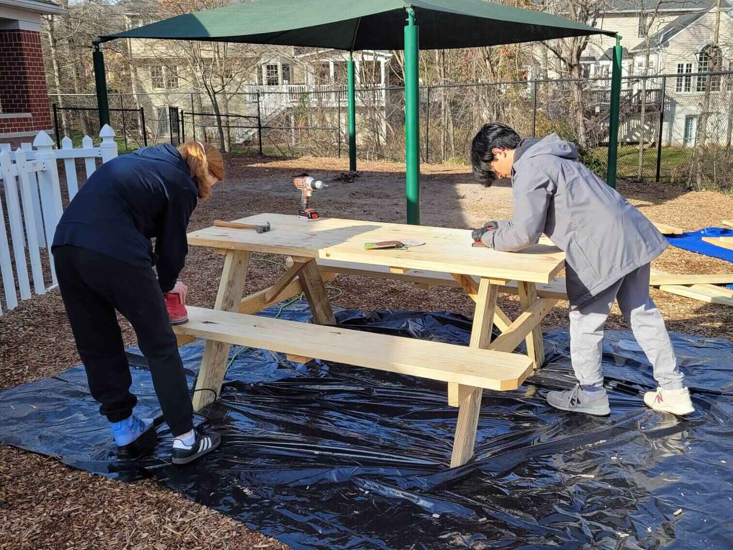 Volunteers sanding down the second table